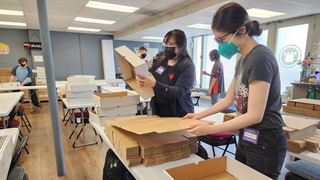Crystal Villamarzo and Michelle Wu construct the boxes for MagiKids kits.